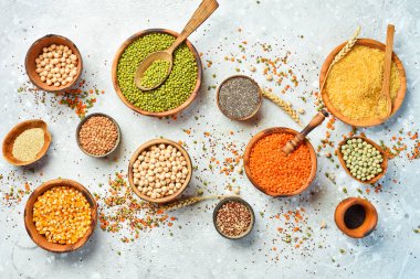 Taş zeminde bir kase baklagil, mercimek, nohut, fasulye, pirinç ve tahıl..