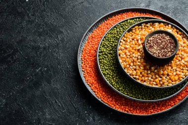 Baklagiller, mercimek, nohut ve fasulye çeşitleri, taş bir masanın üzerinde farklı kaselerde pirinç. Üst Manzara. Sağlıklı yemek..