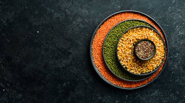 Baklagiller, mercimek, nohut ve fasulye çeşitleri, taş bir masanın üzerinde farklı kaselerde pirinç. Üst Manzara. Sağlıklı yemek..