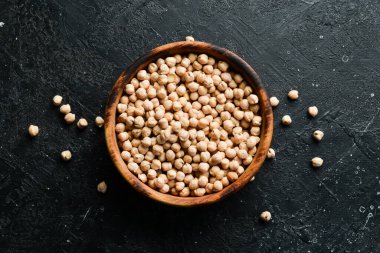 Tahta bir kasede organik nohut fasulyesi. Taş bir arka planda. Sağlıklı yemek..