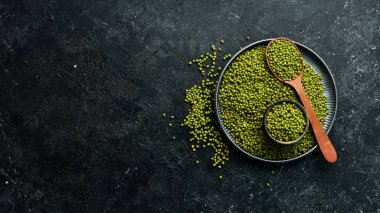 Taş zeminde bir kasede organik yeşil mung fasulyesi. Üst görünüm.