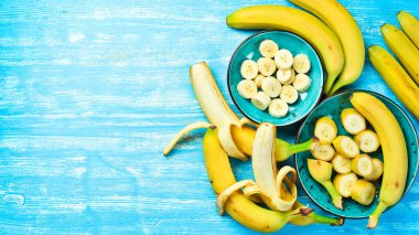 Mavi ahşap arka planda tropik muzlar. Üst görünüm.