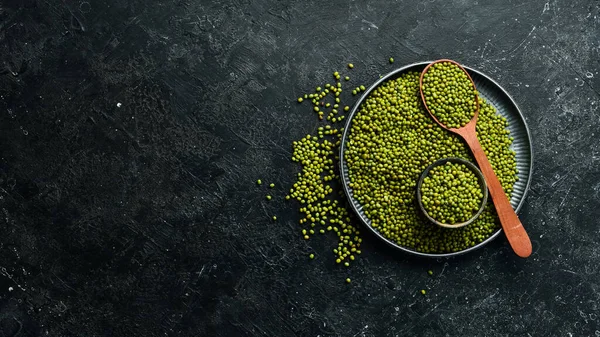 Taş zeminde bir kasede organik yeşil mung fasulyesi. Üst görünüm.