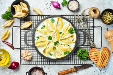 Et, krema sosu ve parmesanla doldurulmuş makarna. Kızartma tavasında. Geleneksel İtalyan yemeği. Taş zeminde. Tarif.