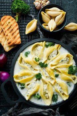 Hindi eti, krema sosu ve parmesanla doldurulmuş makarna. Kızartma tavasında. İtalyan geleneksel mutfağı. Tarif.