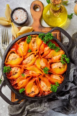 Makarna. Et, domates ve parmesanla pişirilmiş makarna kabukları. Kızartma tavasında. Siyah taştan bir arka planda.