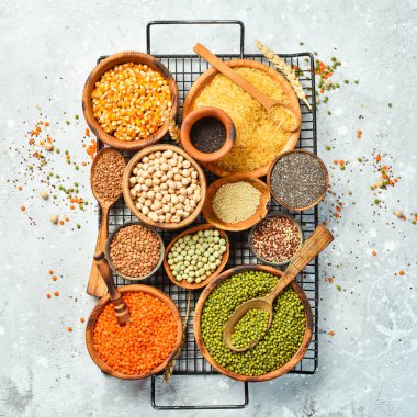 Taş zeminde bir kase baklagil, mercimek, nohut, fasulye, pirinç ve tahıl..