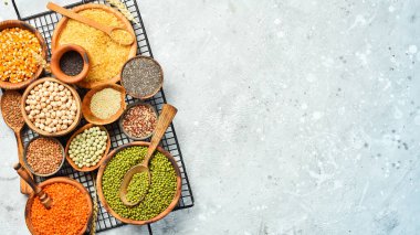 Taş zeminde bir kase baklagil, mercimek, nohut, fasulye, pirinç ve tahıl..