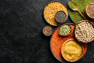 Baklagiller, mercimek, nohut ve fasulye çeşitleri, taş bir masanın üzerinde farklı kaselerde pirinç. Üst Manzara. Sağlıklı yemek..