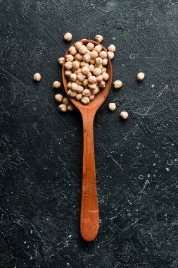 Tahta kaşıkta nohut çekirdeği. Taş bir arka planda. Sağlıklı yemek..