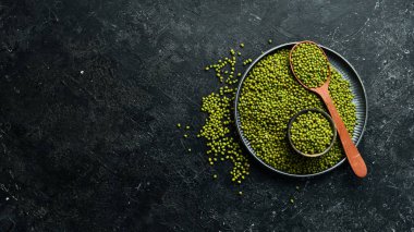 Taş zeminde bir kasede organik yeşil mung fasulyesi. Üst görünüm.