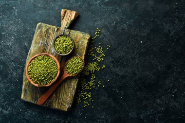 Taş zeminde bir kasede organik yeşil mung fasulyesi. Üst görünüm.