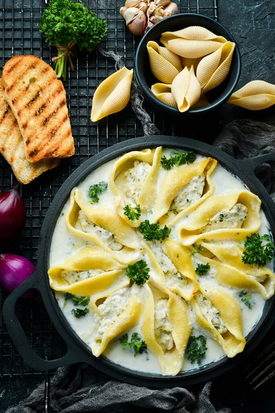 Hindi eti, krema sosu ve parmesanla doldurulmuş makarna. Kızartma tavasında. İtalyan geleneksel mutfağı. Tarif.