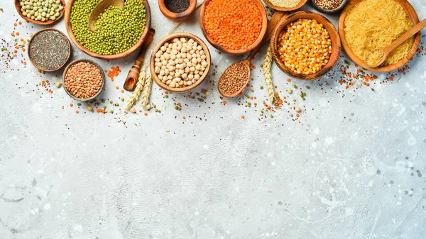 Taş zeminde bir kase baklagil, mercimek, nohut, fasulye, pirinç ve tahıl..