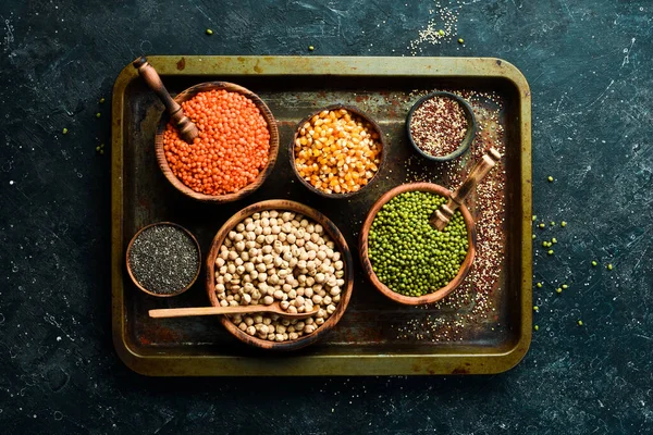 Çeşitli tahıl ve baklagiller: pirinç, bezelye, mercimek, fasulye, fasulye, karabuğday, chia, mısır ve nohut. Üst Manzara. Sitenin başlığında pankart