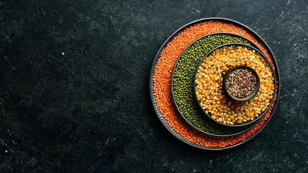 Baklagiller, mercimek, nohut ve fasulye çeşitleri, taş bir masanın üzerinde farklı kaselerde pirinç. Üst Manzara. Sağlıklı yemek..