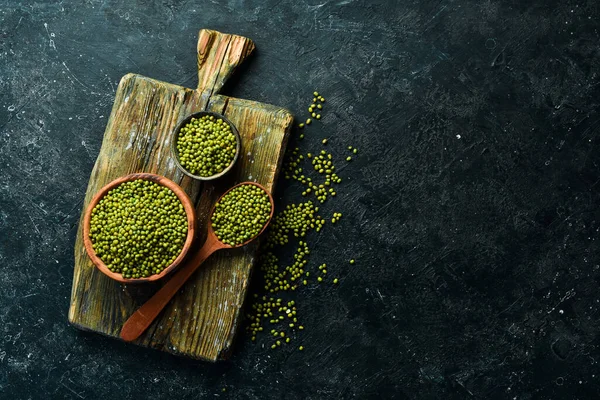 Taş zeminde bir kasede organik yeşil mung fasulyesi. Üst görünüm.