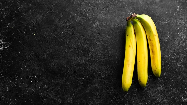 Manojos Tropicales Plátanos Amarillos Sobre Fondo Piedra Negra Vista Superior —  Fotos de Stock