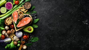 Keto, ketogenik diyet, düşük karbonhidrat, sağlıklı yiyecekler. Siyah taştan bir arka planda. Üst Manzara. Boşluğu kopyala.