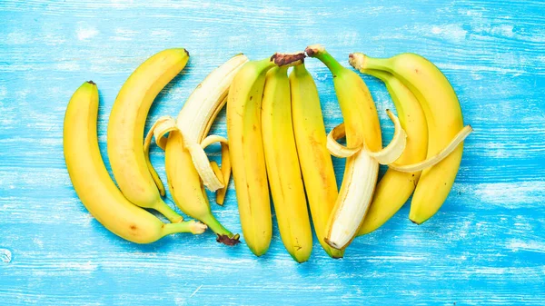 Conjunto Bananas Cruas Frescas Fundo Madeira Azul Vista Superior — Fotografia de Stock