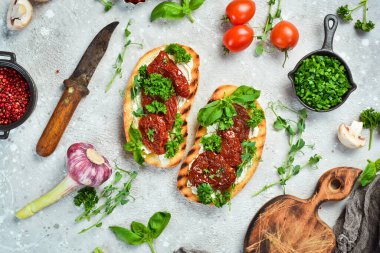 Kurutulmuş domatesli sandviç, peynir ve fesleğen. Allah 'ım. Üst Manzara. Taş bir arka planda.