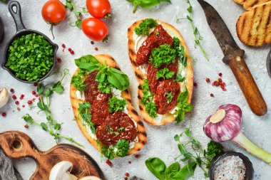 Kurutulmuş domatesli sandviç, peynir ve fesleğen. Allah 'ım. Üst Manzara. Taş bir arka planda.