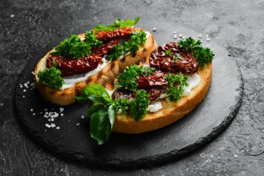 Kurutulmuş domatesli sandviç, peynir ve fesleğen. Allah 'ım. Üst Manzara. Taş bir arka planda.