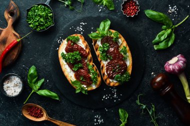 Kurutulmuş domatesli sandviç, peynir ve fesleğen. Allah 'ım. Üst Manzara. Taş bir arka planda.