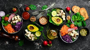 Sağlıklı vejetaryen yemekleri, süper yemekler. Sağlıklı beslenme kavramı. Siyah taştan bir arka planda. Üst görünüm.