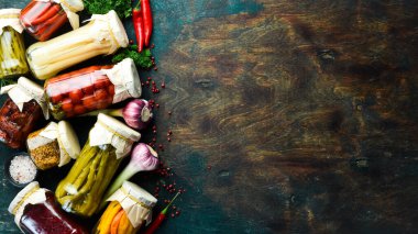 Kavanozlarda sebzeler. Uzun vadeli depolama için cam kavanozlardaki çeşitli sebzeleri tuzlamak. Taş zeminde. Üst görünüm.