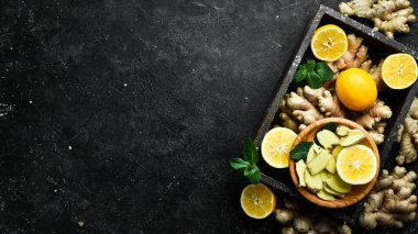 Siyah arka planda taze zencefil, nane ve limon. Üst Manzara. Taş bir arka planda.