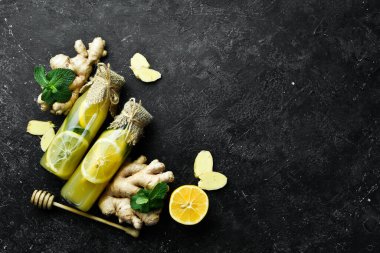Limonlu, zencefilli ve nane yapraklı limonatalı düz kompozisyon. Vitamin Sağlıklı İçecek Konsepti. Siyah taştan bir arka planda.