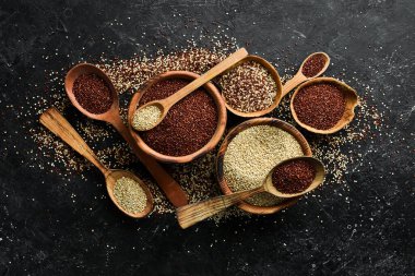 Ahşap mutfak masası manzaralı kinoa tohumları. Sağlıklı ve diyet süper gıda ürünü. Siyah taştan bir arka planda.