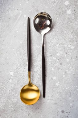 Mutfak arka planı. Metal kaşıklar. Mutfak aletleri. Gri taştan bir arka planda. Üst görünüm.