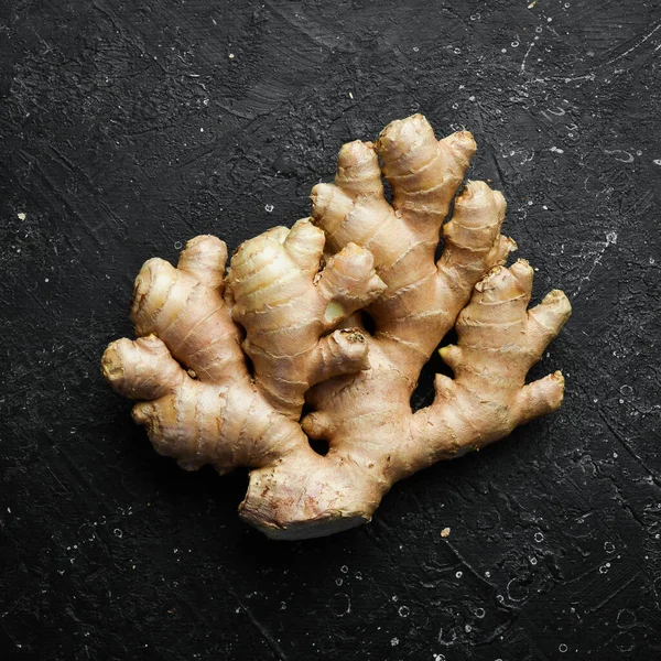 Ginger. Ginger root on a black stone table. Free space for text, on stone background.