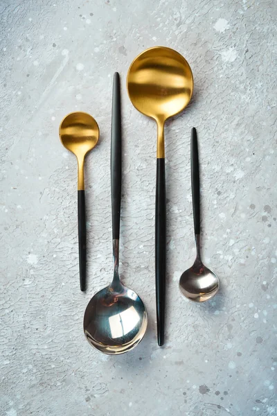 Mutfak arka planı. Metal kaşıklar. Mutfak aletleri. Gri taştan bir arka planda. Üst görünüm.