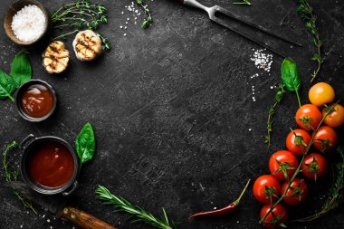Siyah taş pişirme arka planı. Baharat ve sebze. Üst Manzara. Metnin için boş yer.