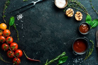 Siyah taş pişirme arka planı. Baharat ve sebze. Üst Manzara. Metnin için boş yer.