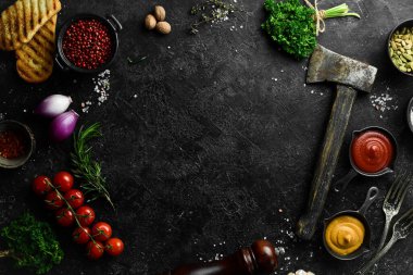 Siyah taş pişirme arka planı. Baharat ve sebze. Üst Manzara. Metnin için boş yer.