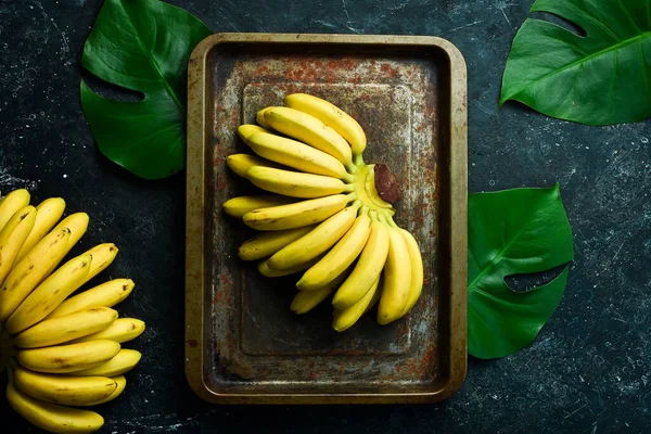 Pequeños Plátanos Tropicales Conjunto Plátanos Sobre Fondo Piedra Negra Espacio —  Fotos de Stock