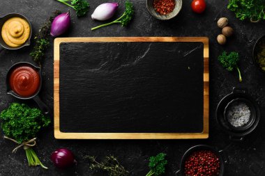 Mutfak tahtası kara tahta. Siyah taştan bir arka planda. Üst görünüm.