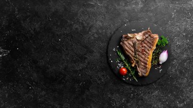 Izgara biftekli biftek. Siyah tabakta biftek. Üst Manzara. Siyah taştan bir arka planda.