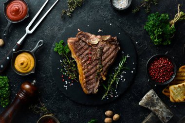 Izgara biftekli biftek. Siyah tabakta biftek. Üst Manzara. Siyah taştan bir arka planda.