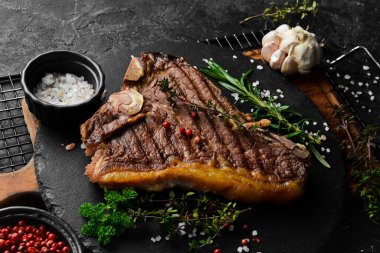 Izgara biftekli biftek. Siyah tabakta biftek. Üst Manzara. Siyah taştan bir arka planda.