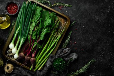 Organik sağlıklı yiyecekler. Taze kuşkonmaz, yeşil soğan ve mutfak masasında kırmızı pancar. Sebzeler. Kırsal biçim.