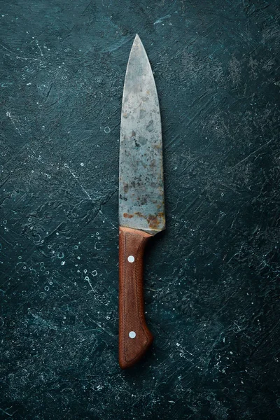 Old knife. Kitchen metal knife. Top view. On a stone background.