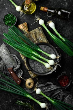 Mutfak masasında taze soğan başları. Üst Manzara. Siyah bir arka planda. Kırsal biçim.