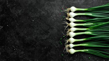 Siyah taşlı arka planda taze soğan. Sağlıklı yiyecekler. Üst görünüm.