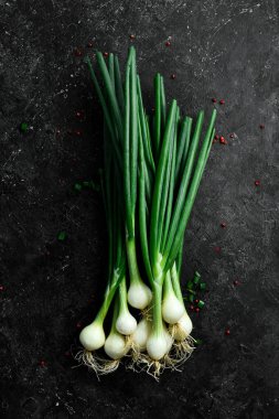 Siyah taşlı arka planda taze soğan. Sağlıklı yiyecekler. Üst görünüm.