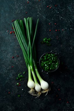 Siyah taşlı arka planda taze soğan. Sağlıklı yiyecekler. Üst görünüm.